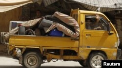 A man waves as he flees Aleppo, July 29, 2012. 