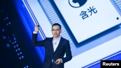 FILE - Alibaba's Chief Technology Officer (CTO) Jeff Zhang holds a new self-developed AI chip Hanguang 800 at the Alibaba Cloud Computing Conference in Yunqi of Hangzhou, Zhejiang province, China September 25, 2019. (REUTERS/Stringer)