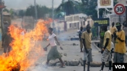 FILE - Protester stand by a burning barricade in the Musaga neighborhood of Bujumbura, Burundi, May 21, 2015. 