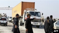 Сотрудники сил безопасности Пакистана перекрывают движение грузовиков на трассе, ведущей в Афганистан