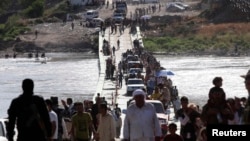 Displaced people from the minority Yazidi sect, fleeing the violence in the Iraqi town of Sinjar, re-enter Iraq from Syria at the Iraqi-Syrian border crossing in Fishkhabour, Dohuk province, Aug. 10, 2014. 