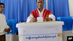 ၂၀၁၀ ခုနှစ်တုန်းက မြန်မာနိုင်ငံရဲ့ ပထမဆုံး ရွေးကောက်ပွဲအတွက် မဲပေးပုံကို ပြသနေတဲ့ ကရင်အမျိုးသားတဦးကို ရန်ကုန်မြို့မှာ တွေ့ရ။ (အောက်တိုဘာ ၀၁၊ ၂၀၁၀)