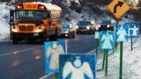 Шкільний автобус зупиняється навпроти 26 фігурок янголів.