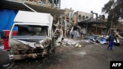 Gente se reunió en los alrededores del sitio de la explosión de un coche bomba en el barrio de Amil, en Bagdad, el martes, 21 de marzo, de 2017.
