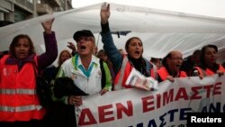 Protesters hold a plastic sheet to protect themselves from the rain as they take part in an anti-austerity rally during a 24-hour general labour strike in Athens November 6, 2013. Thousands of striking Greek workers marched to parliament in pouring rain o