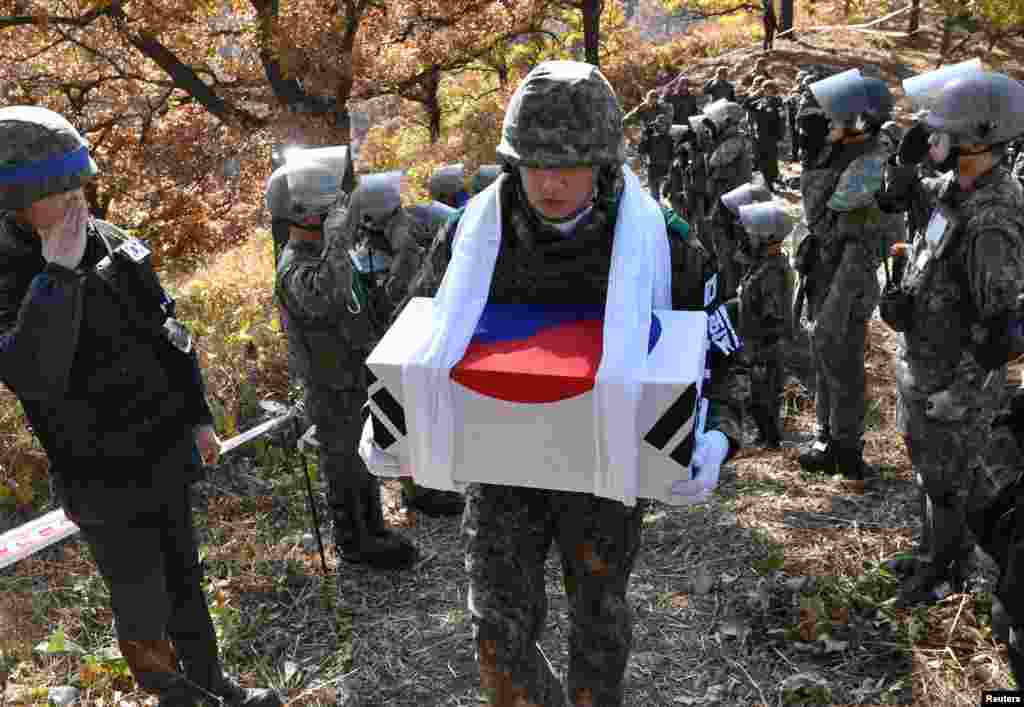 A South Korean soldier carries a casket containing a piece of bone believed to be the remains of an unidentified South Korean soldier killed in the Korean War in the Demilitarized Zone (DMZ) dividing the two Koreas in Cheorwon.