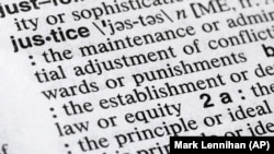 In this December 12, 2018, photo, "justice" is shown in a Merriam-Webster dictionary in New York. (AP Photo/Mark Lennihan)