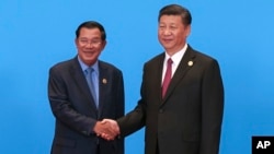 Cambodian Prime Minister Hun Sen, left, and Chinese President Xi Jinping, right, shake hands during the welcome ceremony for the Belt and Road Forum, at the International Conference Center at Yanqi Lake in Beijing, Monday, May 15, 2017. (Roman Pilipey/Pool Photo via AP)
