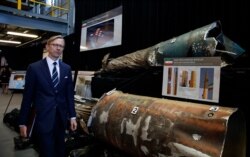 FILE - Brian Hook, U.S. special envoy for Iran, walks past pieces of Iranian missiles at Joint Base Anacostia-Bolling, Washington, Nov. 29, 2018.