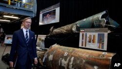 FILE - Brian Hook, U.S. special envoy for Iran, walks past pieces of Iranian missiles at Joint Base Anacostia-Bolling, Washington, Nov. 29, 2018. The U.S. wants to extend a U.N. arms embargo against Iran due to expire soon.