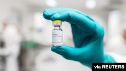 A lab worker holds a vial of Johnson & Johnson's Janssen coronavirus disease vaccine candidate in an undated photograph.