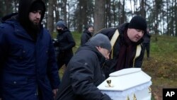 A Polish imam, right, and two other members of a Muslim community bury the tiny white casket of an unborn Iraqi boy, in Bohoniki, Poland.&nbsp;The child is the latest life claimed as thousands of migrants from the Middle East have sought to enter the European Union.