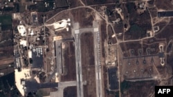 FILE - This handout image taken by EADS' Astrium Press on Sept. 20, 2015, by Pleiades Satellite purports to show a view of Russian fighter jets and helicopters at a military base in Latakia, Syria.