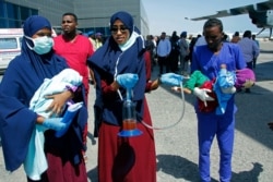Medical personnel carry wounded children to be airlifted to the Turkish capital for treatment after they were injured in Saturday's car bomb blast in Mogadishu, Dec. 29, 2019.