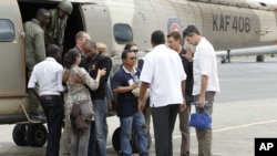 Des travailleurs humanitaires de la Norwegian Refugee Council (NRC) après leur libération, sont accueillis par leurs collègues à leur descente d’un hélicoptère à l'aéroport Wilson du Kenya Air Force, à Nairobi, 2 juillet 2012.