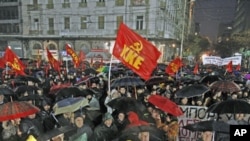 Demonstrators take part in a protest rally of the Greek Communist party against new austerity measures during heavy rainfall, in Athens, Greece, February 6, 2012.