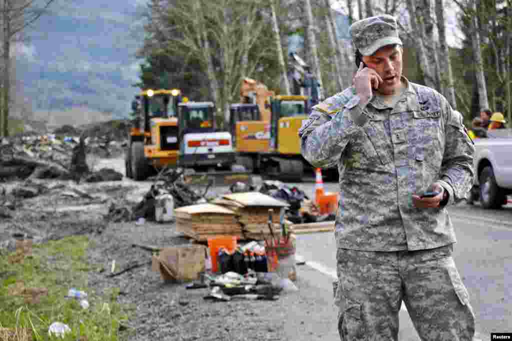 Chief Warrant Officer Kevin Crisp, liaison officer for the Washington National Guard, coordinates the arrival of the Search and Extraction team at the site of the mudslide in Oso, Washington, March 26, 2014.