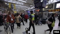 Seorang polisi Inggris dengan anjingnya berpatroli di stasiun kereta kota London.