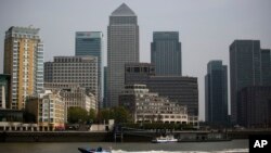 La sede global de HSBC (centro izquierda), junto a otros rascacielos en el distrito financiero Canary Wharf en Londres, continuará estando en la capital birtánica.