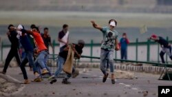 Kashmiri Muslim protesters throw stones at Indian troops in Srinagar, Indian-controlled Kashmir, July 12, 2016. Violence erupted following the Friday killing of rebel commander Burhan Wani.