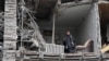 A resident stands in her flat in an apartment building hit by a Russian missile strike in Zaporizhzhia, Ukraine, Jan. 23, 2025. 