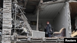 A resident stands in her flat in an apartment building hit by a Russian missile strike in Zaporizhzhia, Ukraine, Jan. 23, 2025. 