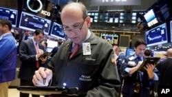 Trader Andrew Silverman (c) works on the floor of the New York Stock Exchange, Dec. 2, 2015. 