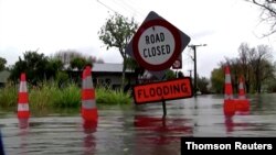 Video grab of a sign reading "Road Closed. Flooding" in floodwaters in Canterbury region, New Zealand, May 30, 2021.