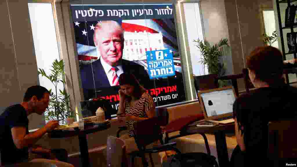 Quelques personnes regardent la soirée électorale du nouveau président américain Donald Trump sur un écran dans une cafétéria à Tel Aviv, en Israël, le 9 novembre 2016. 