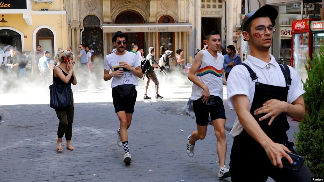 Para aktivis LGBT berlarian saat polisi menembakkan gas air mata dalam acara parade LGBT, yang dilarang di Istanbul, Turki Minggu (30/6).
