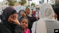 在加沙阿克萨烈士医院太平间外，巴勒斯坦妇女在以色列空袭中丧生的亲属遗体旁哀悼。(2024年6月10日)