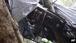 A rescuer takes a picture of a clamp that was placed on an emergency brake, as search for evidence continues in the wreckage the cable car that collapsed in the Piedmont region, Italy on May 26, 2021 that killed 14 people.