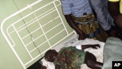 A boy, the only survivor of an overnight gang attack in the village of Vwang Fwil, lies on a hospital bed in the Nigerian central city of Jos, September 10, 2011.