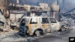 A scorched vehicle sits next to a burned-out building in Gatlinburg, Tennessee, Nov. 29, 2016. 