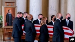 The flag-draped casket of Justice Ruth Bader Ginsburg, carried by Supreme Court police officers, arrives in the Great Hall at the Supreme Court in Washington, Sept. 23, 2020. 