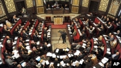 Syrian lawmakers gather during a session to vote for a new election law, at the Syrian parliament in Damascus, Syria, March 11, 2014.