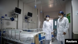 Nurses walk inside a quarantine room for coronavirus patients at finished but still unused building A2 of the Shanghai Public Clinical Center, in Shanghai, China, Feb. 17, 2020. 