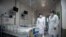 Nurses walk inside a quarantine room for coronavirus patients at finished but still unused building A2 of the Shanghai Public Clinical Center, in Shanghai, China, Feb. 17, 2020. 