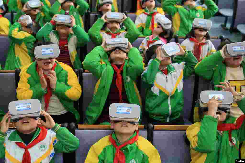 Primary school students wear virtual reality (VR) headsets inside a classroom in Xiangxi Tujia and Miao Autonomous Prefecture, Hunan province, China, March 14, 2018.