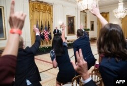Reporters raise their hands as they shout questions to President Joe Biden after speaking about COVID-19 vaccinations in the East Room of the White House in Washington, July 29, 2021.