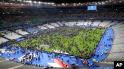 Spectators rush onto the field at Stade de France stadium after an explosion nearby, Nov. 13, 2015.