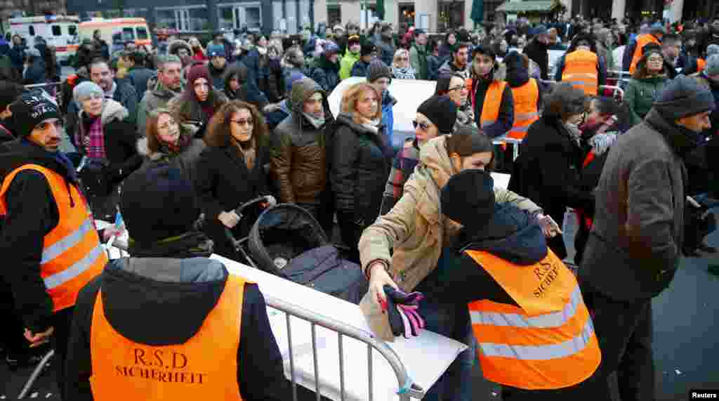 Orang-orang melalui pemeriksaan keamanan di tempat perayaan Tahun Baru di pintu masuk Brandenburger Tor di Berlin, Jerman.