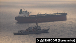 ناوشکن موشک‌انداز یواس‌اس رافائل پرالتا و یک کشتی حامل پرچم جمهوری اسلامی