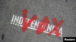 FILE - The name of the Spanish right-wing party Vox is sprayed over the graffiti stencil reading "Independence" on sidewalk in Barcelona, Spain, Dec. 12, 2018.