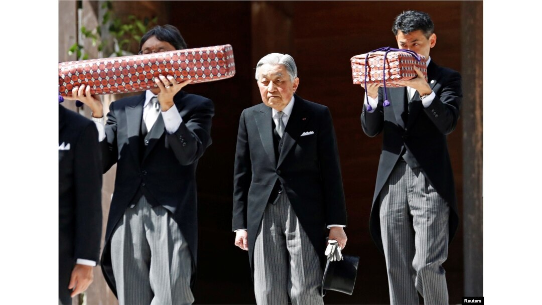Kaisar Akihito berjalan keluar ruangan sementara beberapa pejabat berwenang mengambil “regalia kekaisaran” yang ada di dalam kotak, Senin (30/4).