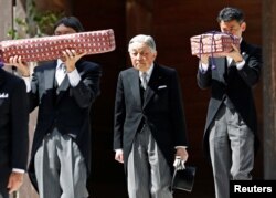 Japan's Emperor Akihito, flanked by Imperial Household Agency officials carrying two of the so-called Three Sacred Treasures of Japan, leaves the main sanctuary as he visits the Inner shrine of the Ise Jingu shrine.