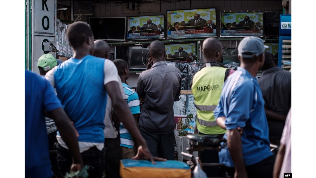 People watch a live broadcast of the announcement of the re-election results by Kenya's Independent Electoral and Boundaries Commission (IEBC) chairman, Wafula Chebukat, on TV at a local electrical shop in Kisumu, Oct. 30, 2017.