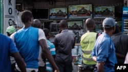 FILE - People watch a live broadcast of the announcement of the re-election results by Kenya's Independent Electoral and Boundaries Commission (IEBC) chairman, Wafula Chebukat, on TV at a local electrical shop in Kisumu, Oct. 30, 2017.