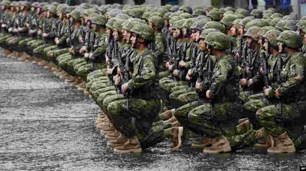 Georgian soldiers listen the national anthem as they mark an Independence Day in Tbilisi. 