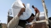 FILE - A man carries a sack of food aid from the WFP, at the Um Rakuba refugee camp in Sudan, where Tigray refugees stay, Dec. 3, 2020.